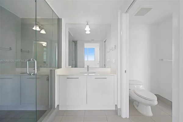 a bathroom with a toilet a sink a mirror and vanity