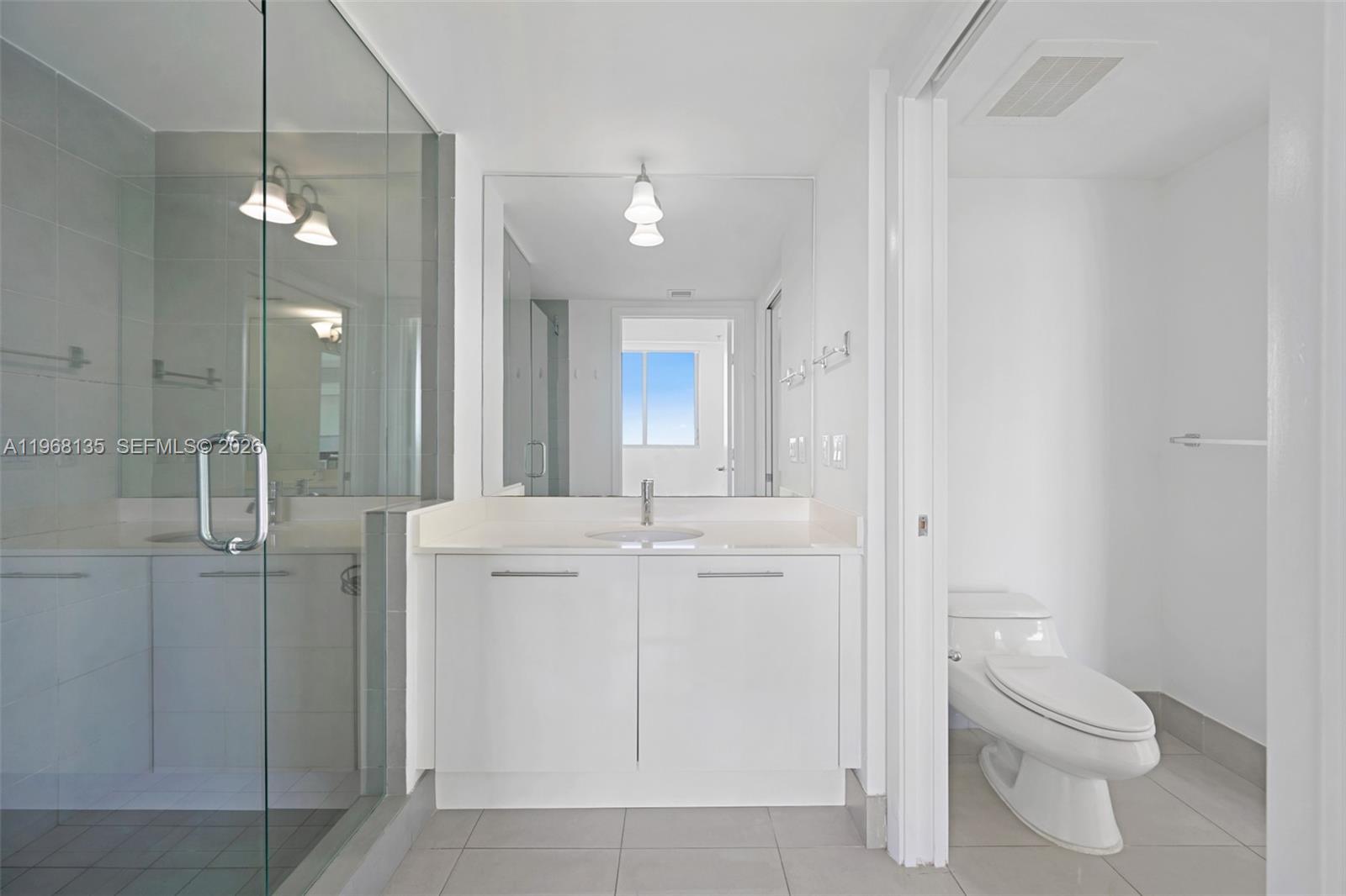 92 Southwest 3rd Street, Unit 5109 Miami, FL 33130 - Photo 12 of 27 a bathroom with a toilet a sink a mirror and vanity