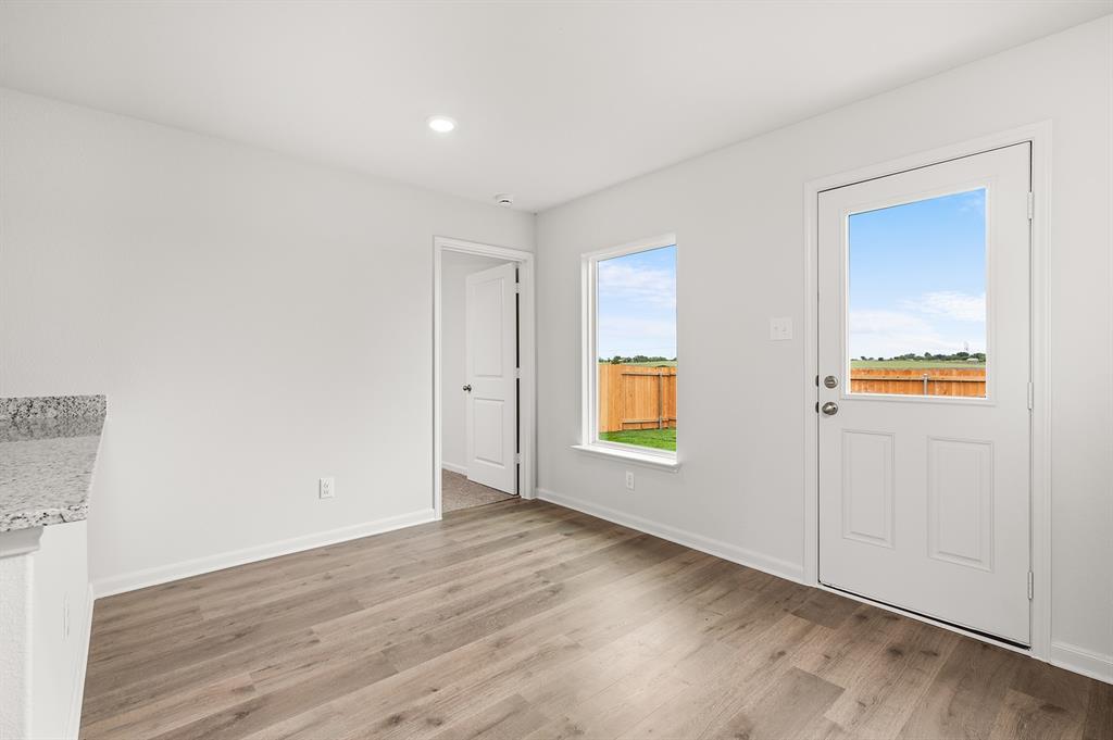 307 Patton Lane Venus, TX 76084 - Photo 4 of 8 an empty room with a window and a wooden floor