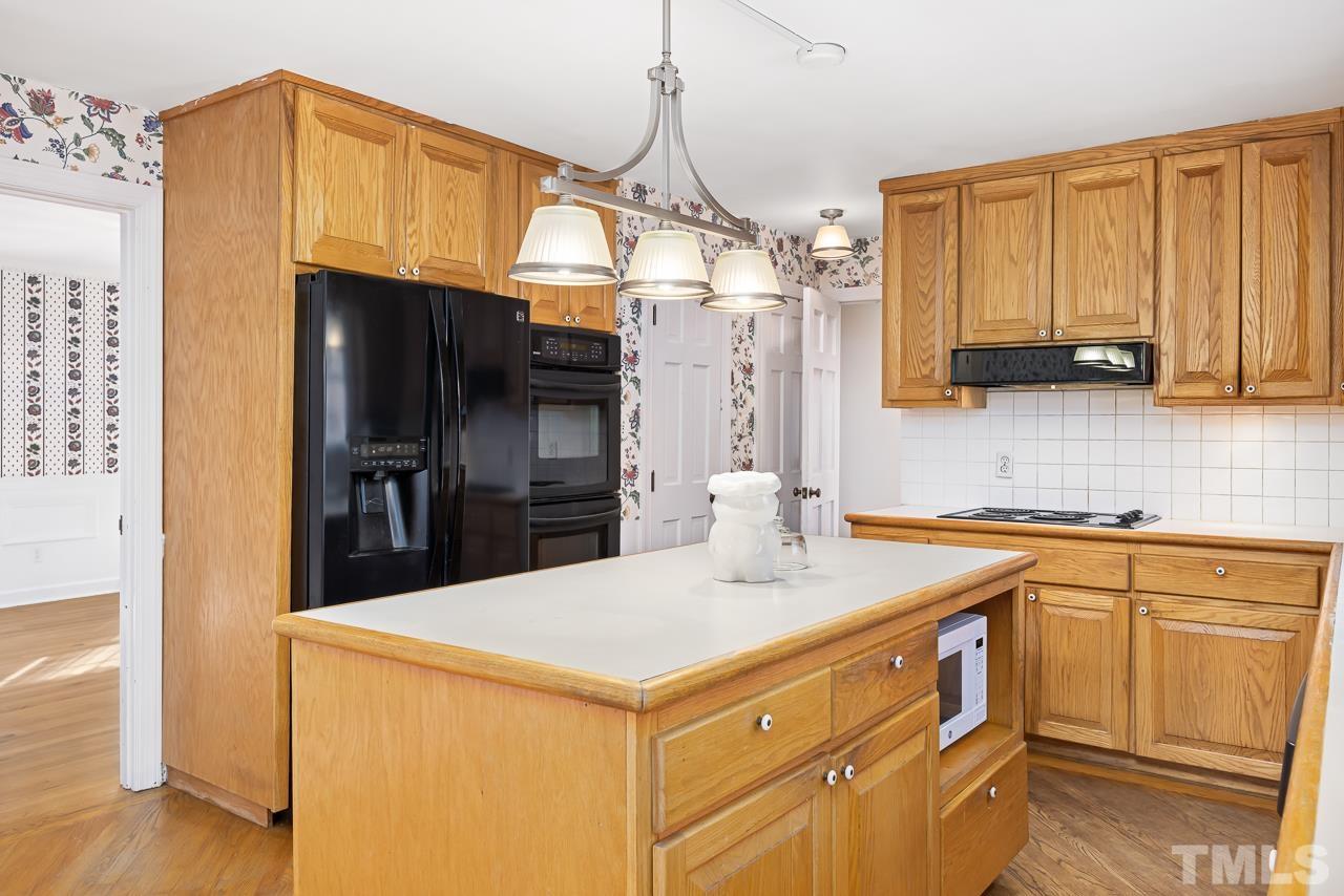 3100 Braddock Drive Raleigh, NC 27612 - Photo 11 of 40 a kitchen that has a kitchen island wooden cabinets and refrigerator