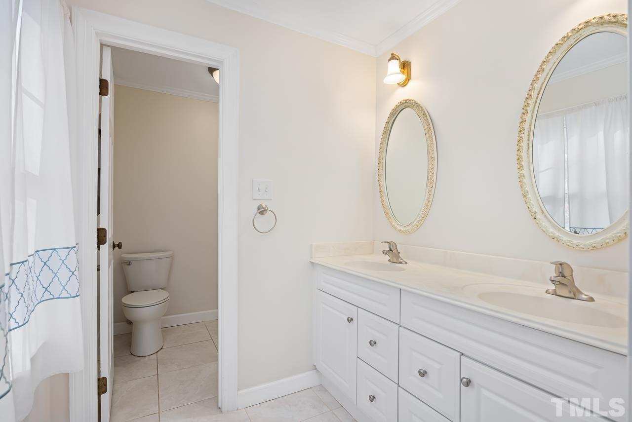 3100 Braddock Drive Raleigh, NC 27612 - Photo 20 of 40 a bathroom with 2 sink and a mirror
