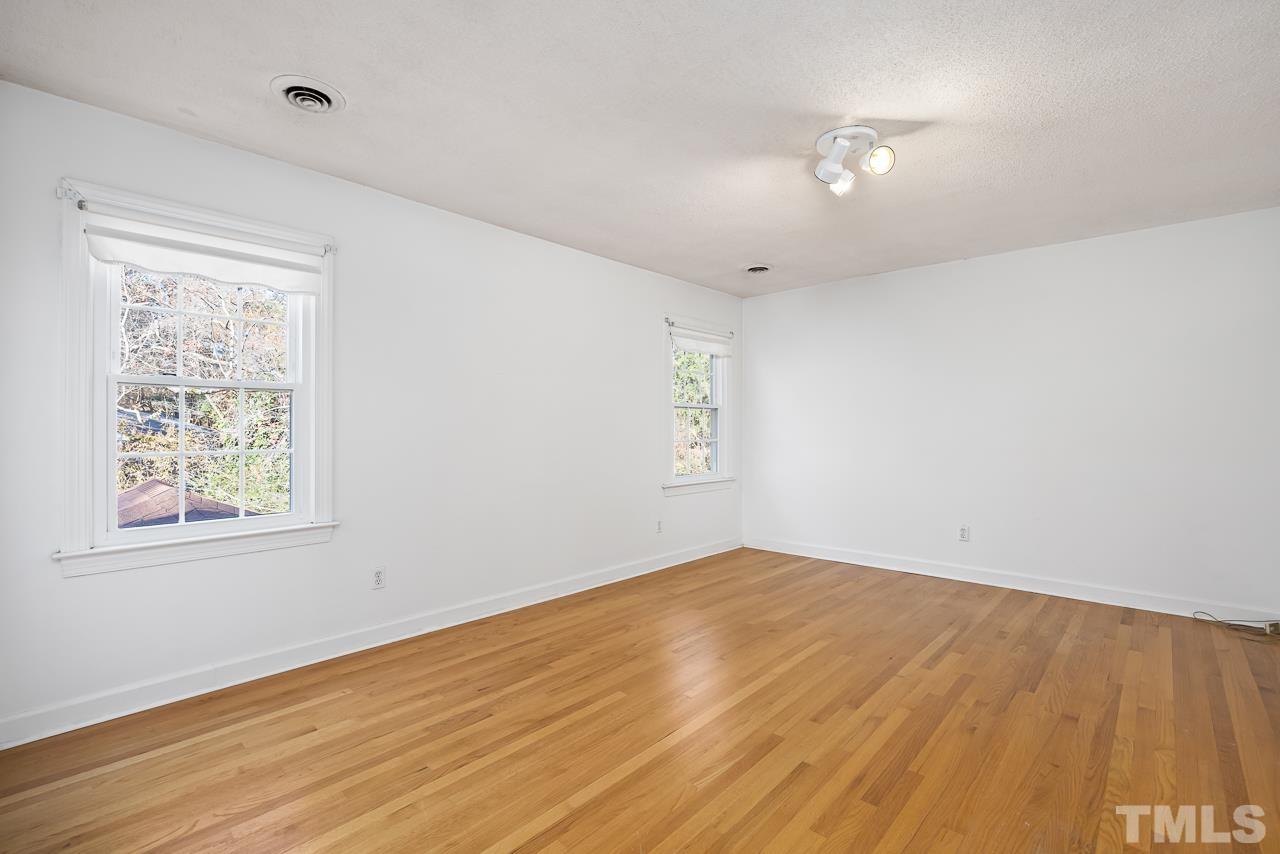 3100 Braddock Drive Raleigh, NC 27612 - Photo 24 of 40 an empty room with wooden floor and windows