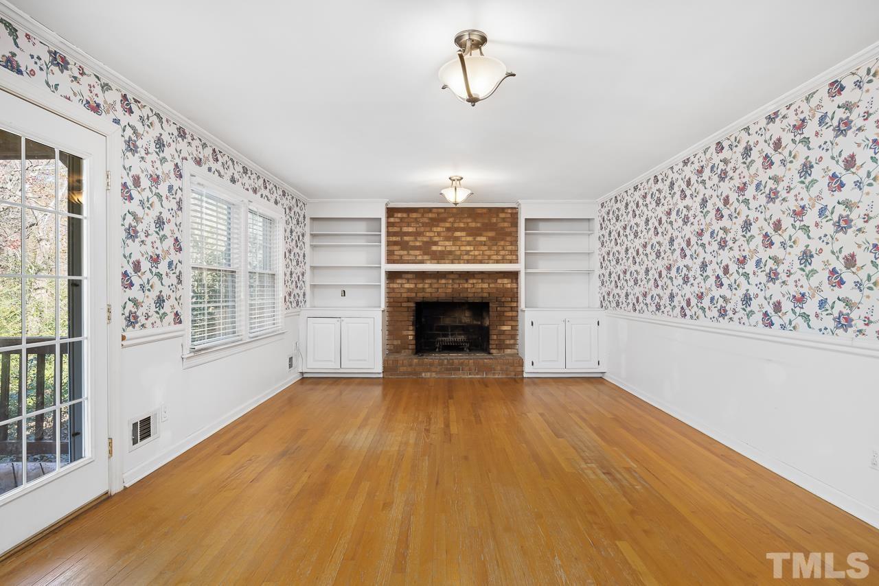 3100 Braddock Drive Raleigh, NC 27612 - Photo 7 of 40 a view of an empty room with a fireplace and a window