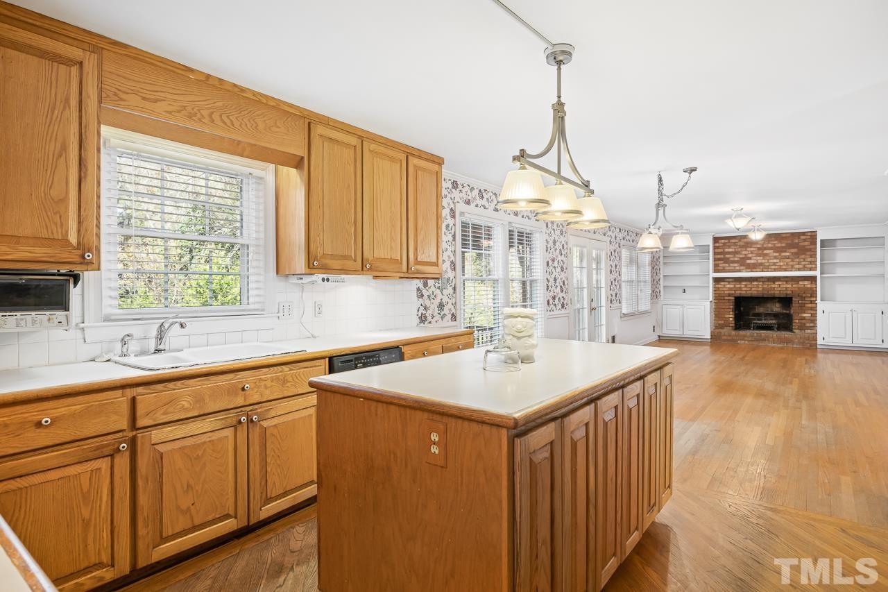 3100 Braddock Drive Raleigh, NC 27612 - Photo 10 of 40 a kitchen with sink cabinets and wooden floor