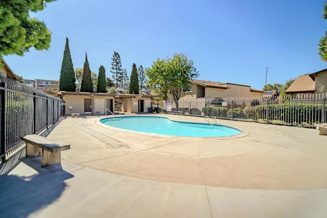 a front view of a house with a garden and trees