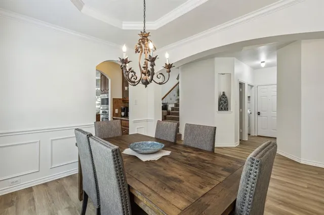 a view of a dining room with furniture wooden floor and chandelier