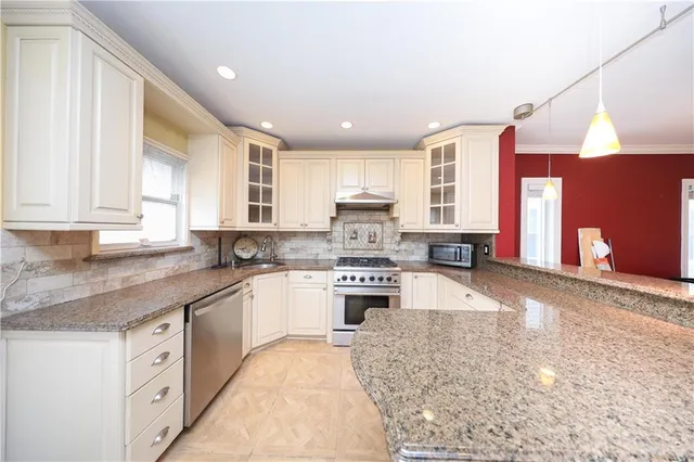 a large kitchen with granite countertop a sink counter space cabinets and stainless steel appliances