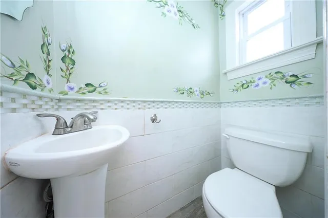 a bathroom with a toilet sink and mirror