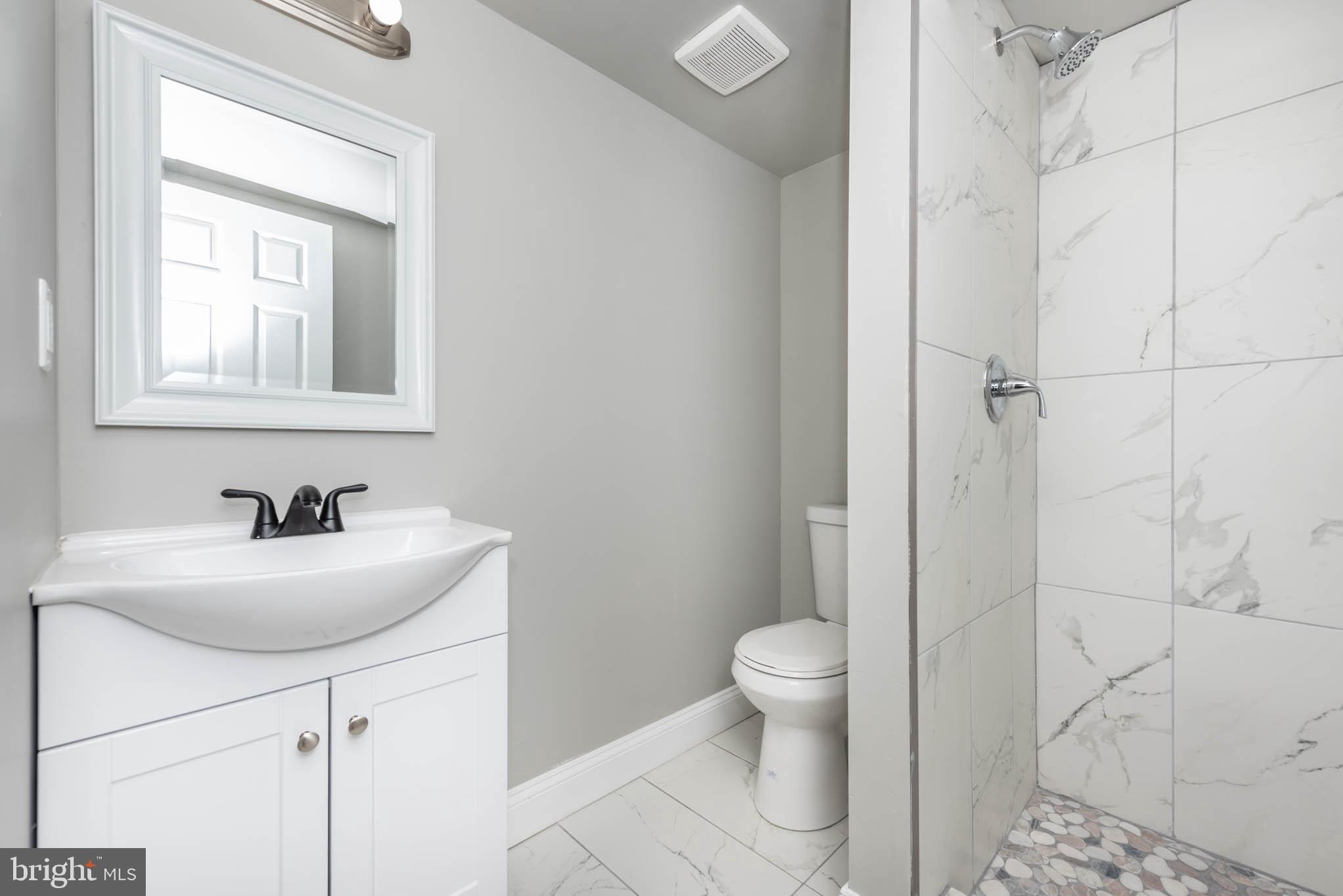 4001 Ridgecroft Road Baltimore, MD 21206 - Photo 26 of 35 a bathroom with a sink a toilet and a mirror