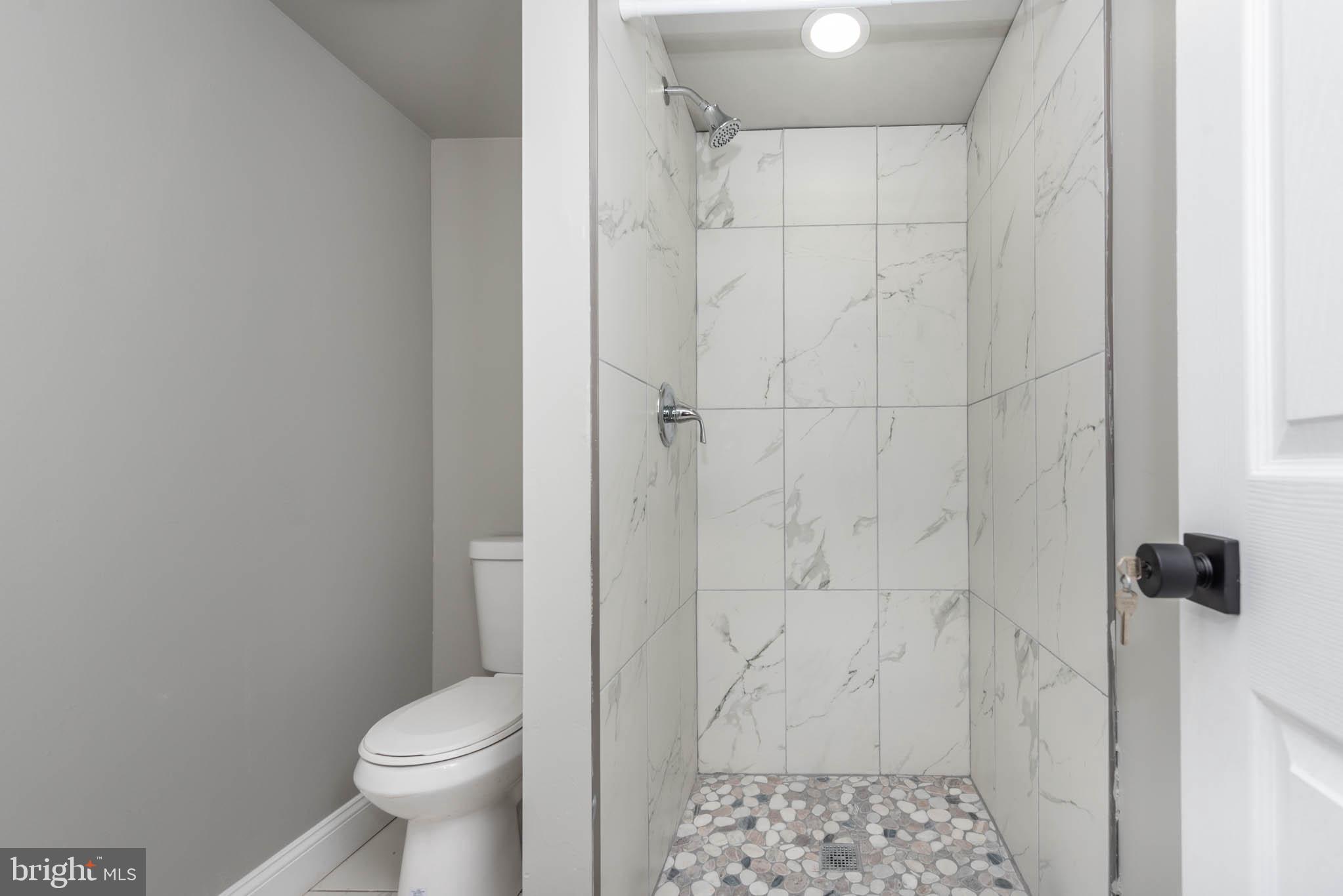 4001 Ridgecroft Road Baltimore, MD 21206 - Photo 27 of 35 a bathroom with a granite countertop toilet and a shower