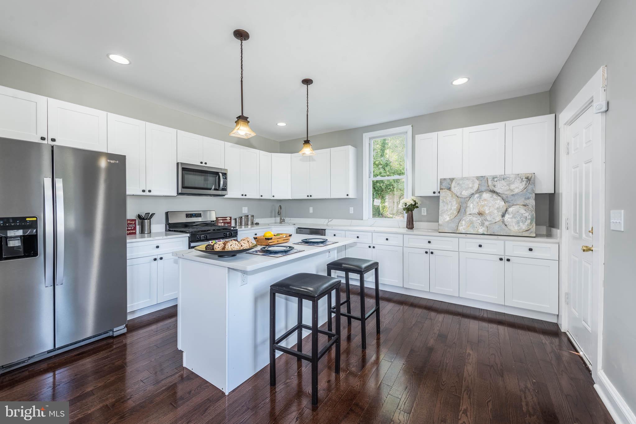 4001 Ridgecroft Road Baltimore, MD 21206 - Photo 7 of 35 a kitchen with white cabinets and stainless steel appliances