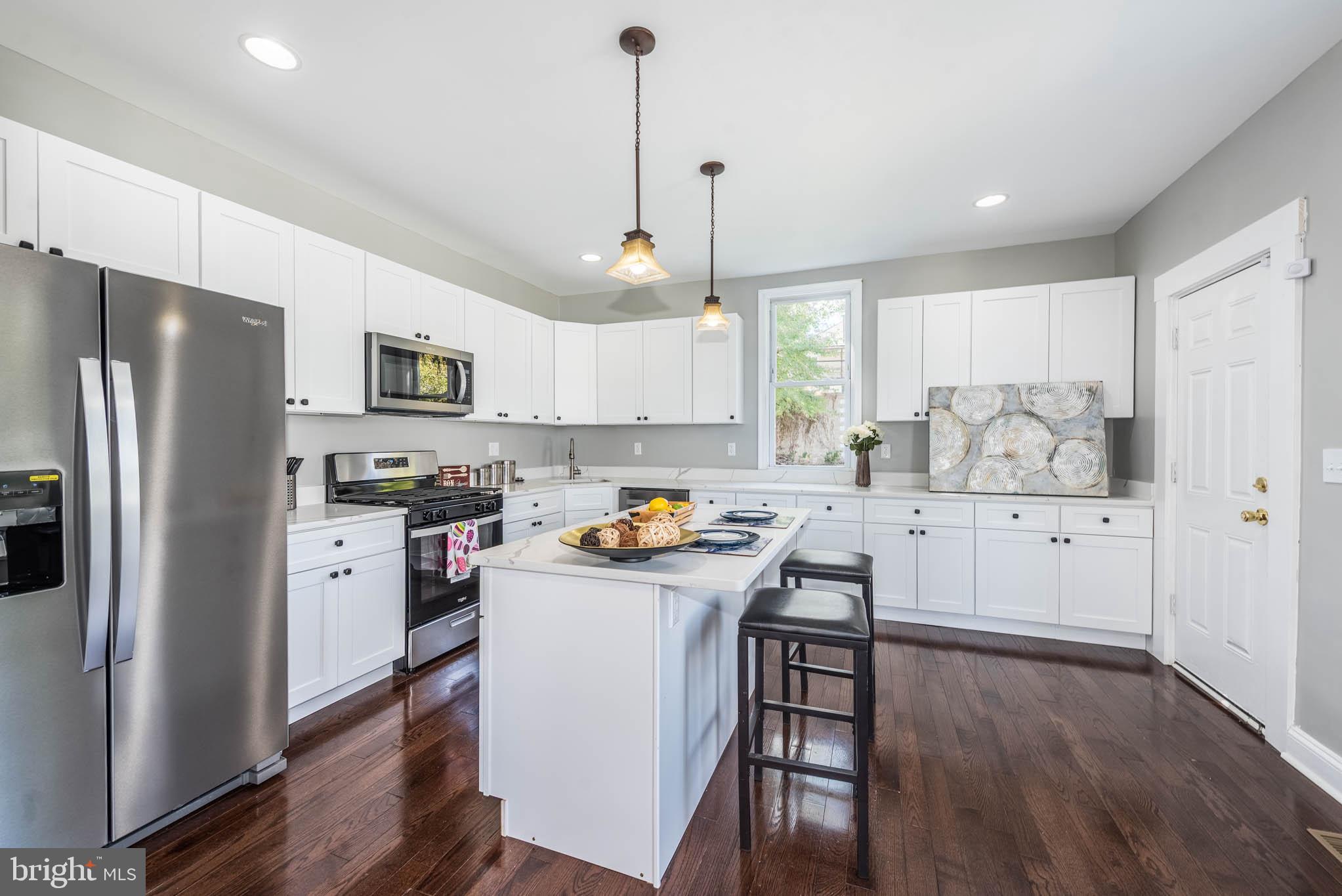 4001 Ridgecroft Road Baltimore, MD 21206 - Photo 9 of 35 a kitchen with white cabinets and stainless steel appliances