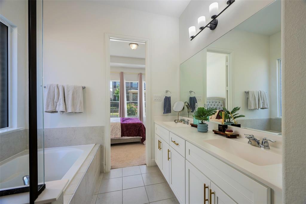 3603 Scotsman Road Sachse, TX 75048 - Photo 17 of 33 a en suite bathroom with a double vanity sink a mirror and a bathtub