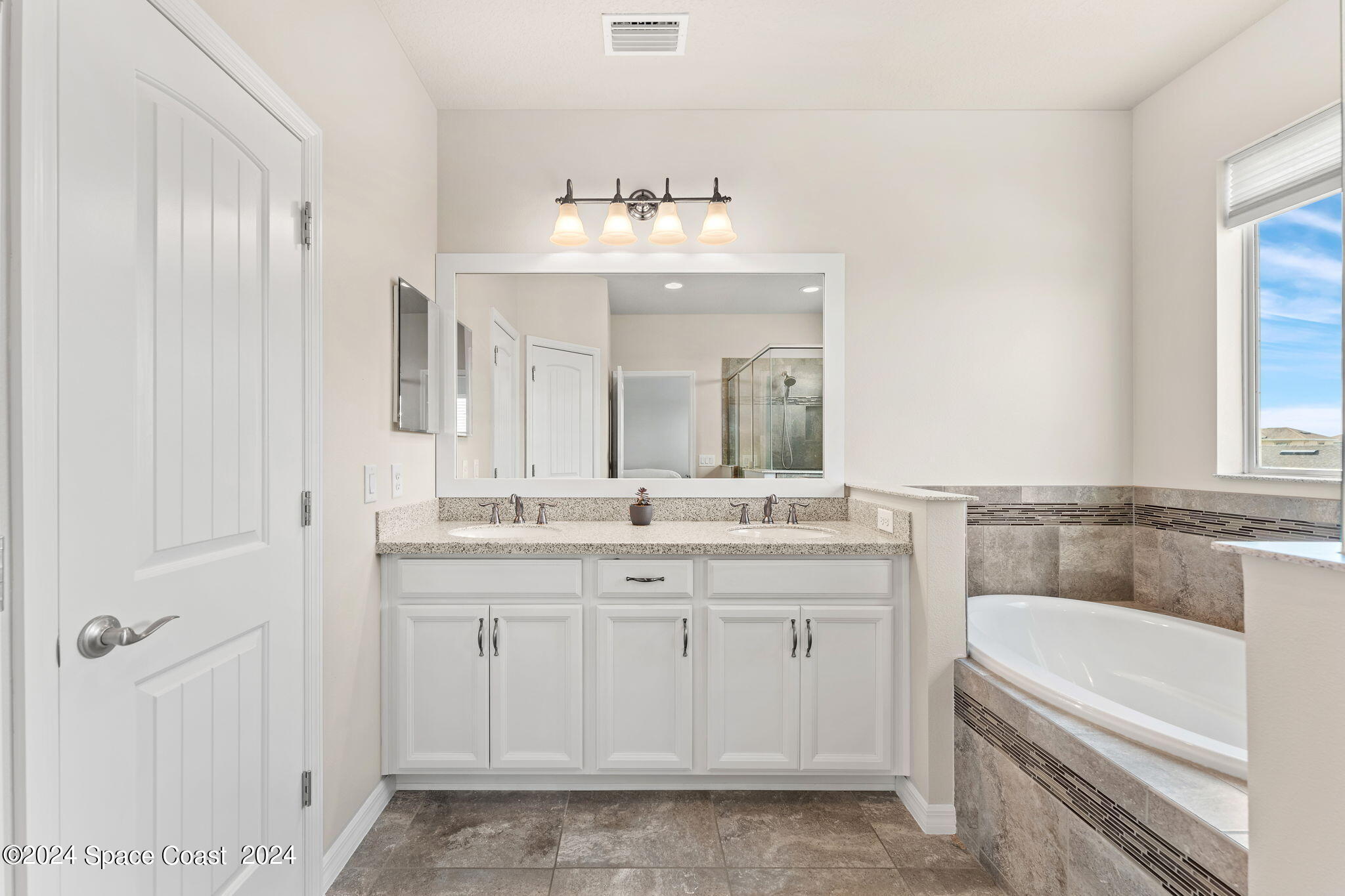 2850 Amethyst Way Melbourne, FL 32940 - Photo 16 of 37 a bathroom with a sink vanity tub and a mirror