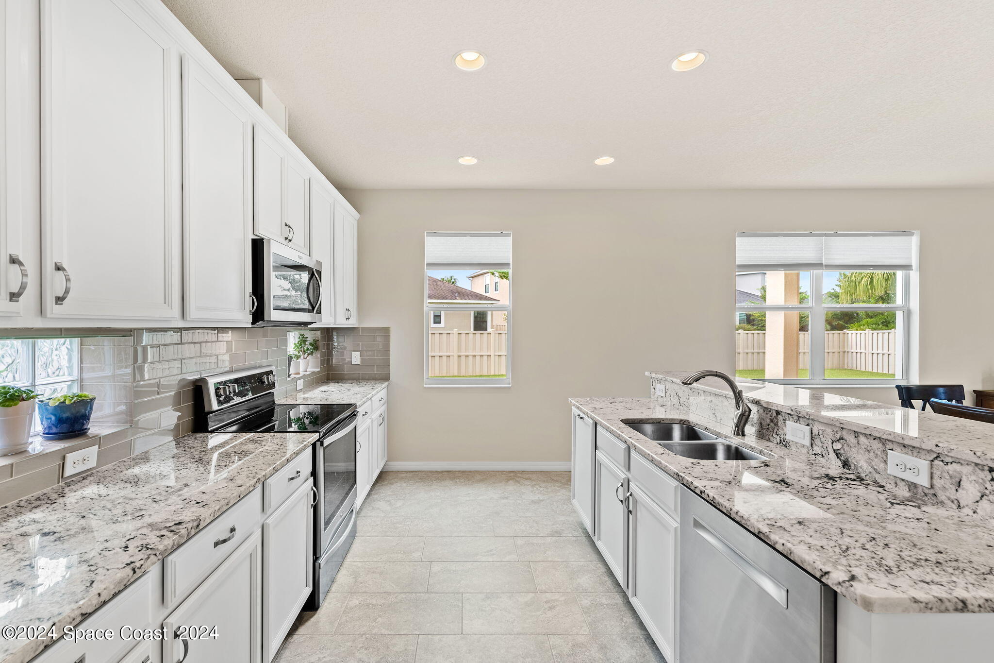 2850 Amethyst Way Melbourne, FL 32940 - Photo 10 of 37 a large white kitchen with stainless steel appliances granite countertop a sink stove and cabinets
