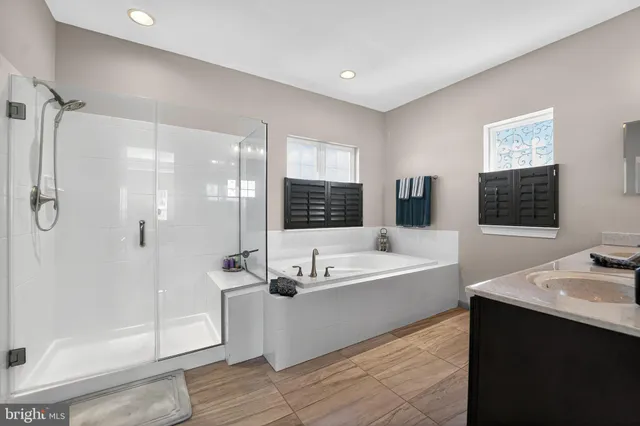 a bedroom with a bed a flat screen tv and a large window