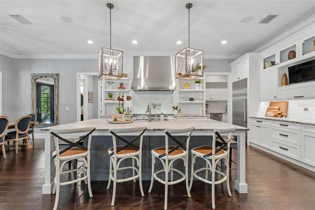 17001 Midas Lane Lutz, FL 33549 - Photo 18 of 100 a kitchen with stainless steel appliances kitchen island granite countertop a dining table chairs sink and white cabinets