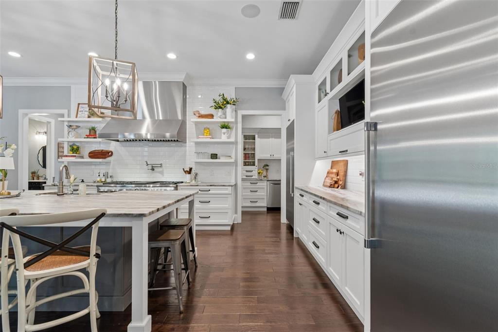 17001 Midas Lane Lutz, FL 33549 - Photo 24 of 100 a kitchen with stainless steel appliances kitchen island granite countertop a table chairs in it and wooden floors