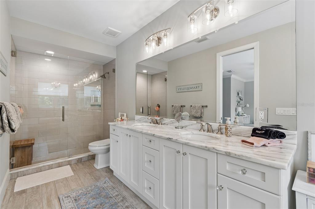 17001 Midas Lane Lutz, FL 33549 - Photo 60 of 100 a bathroom with a double vanity sink a toilet a mirror and shower