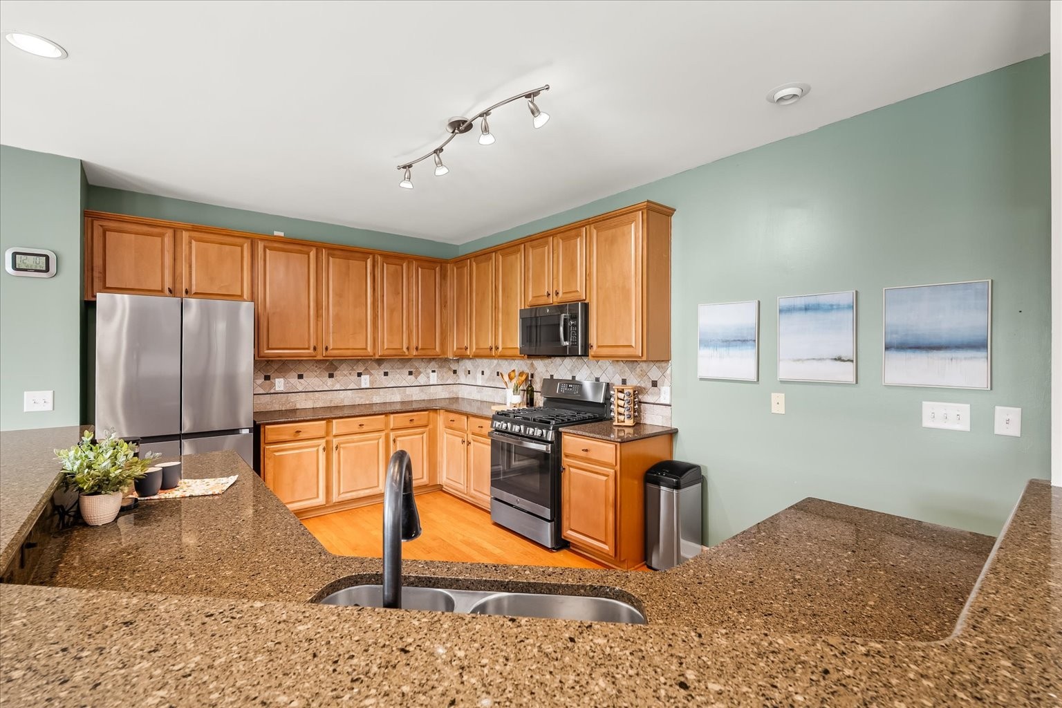 4055 Williford Way Spring Hill, TN 37174 - Photo 7 of 37 a kitchen with stainless steel appliances granite countertop a stove top oven a sink dishwasher a dining table and chairs with wooden floor
