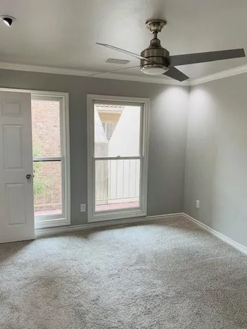 an empty room with windows and chandelier fan