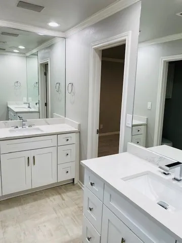 a spacious bathroom with a granite countertop sink and a mirror