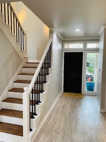 a view of staircase with wooden floor and white walls