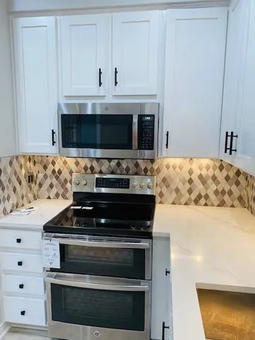 a kitchen with granite countertop a stove and a microwave