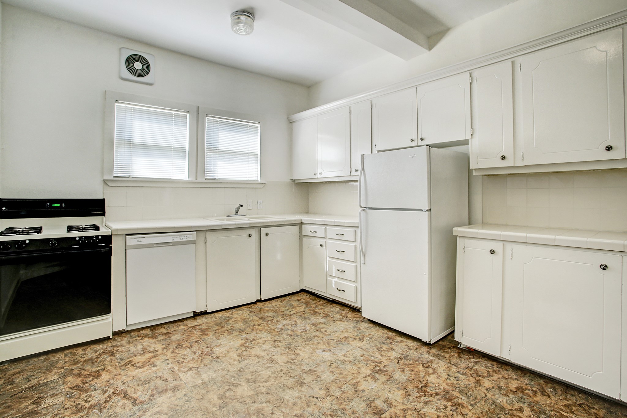 1127 Yale Street, Unit B Houston, TX 77008 - Photo 11 of 14 a kitchen with white cabinets and white appliances