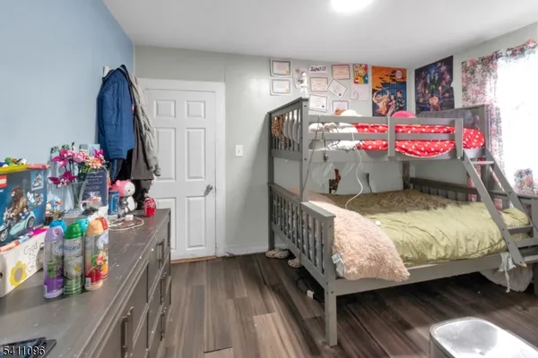 a bedroom with bed and wooden floor