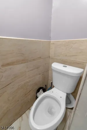a white toilet sitting next to a white wall