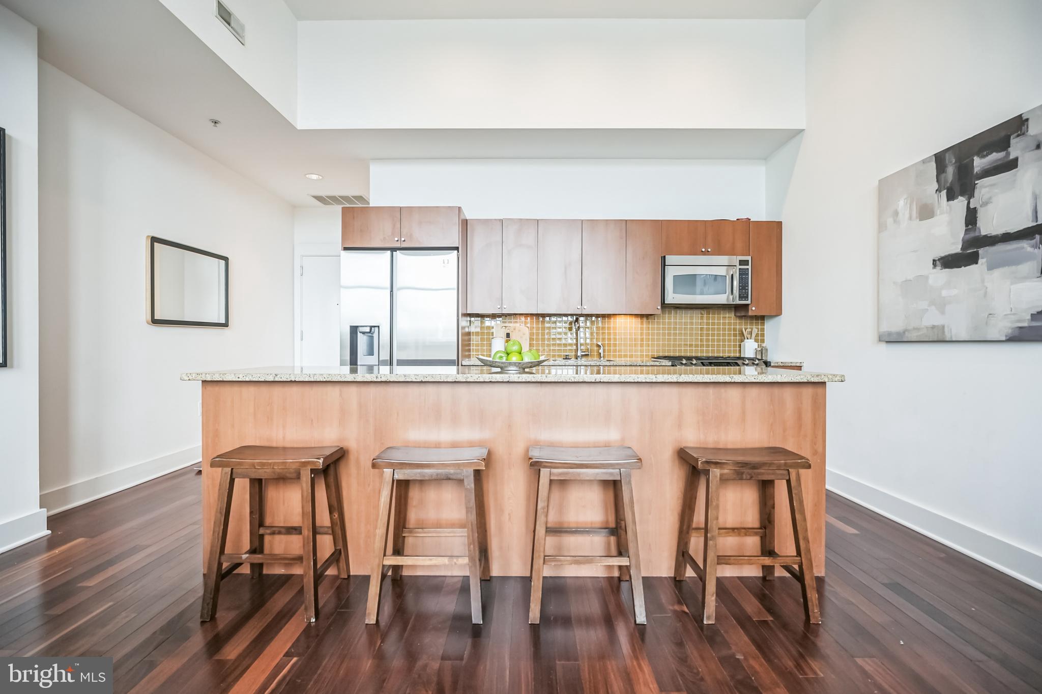 1101 Locust Street, Unit 4E Philadelphia, PA 19107 - Photo 5 of 15 a kitchen with dining table chairs and wooden floor
