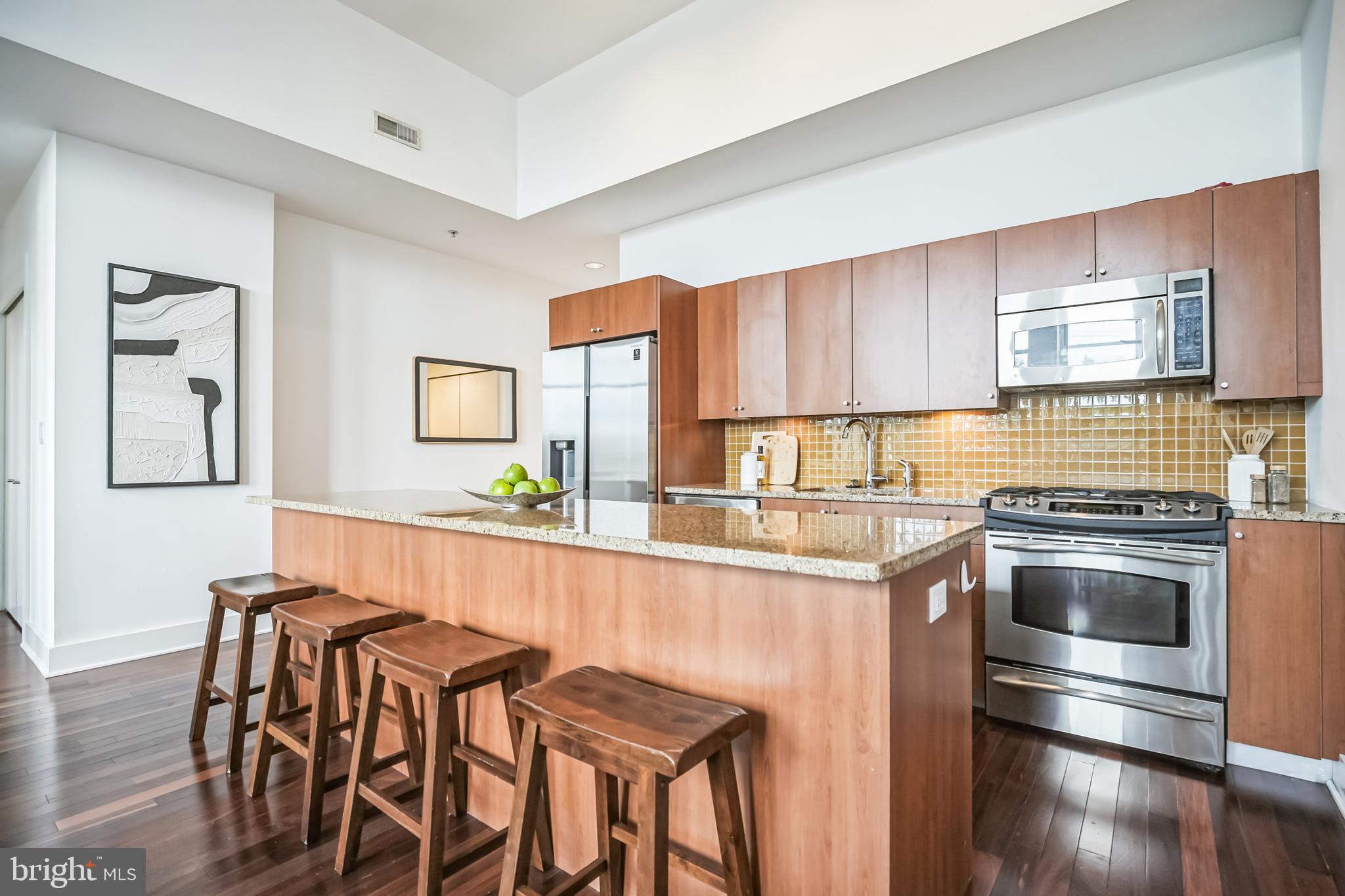 1101 Locust Street, Unit 4E Philadelphia, PA 19107 - Photo 6 of 15 a kitchen with stainless steel appliances granite countertop a stove a sink and a refrigerator