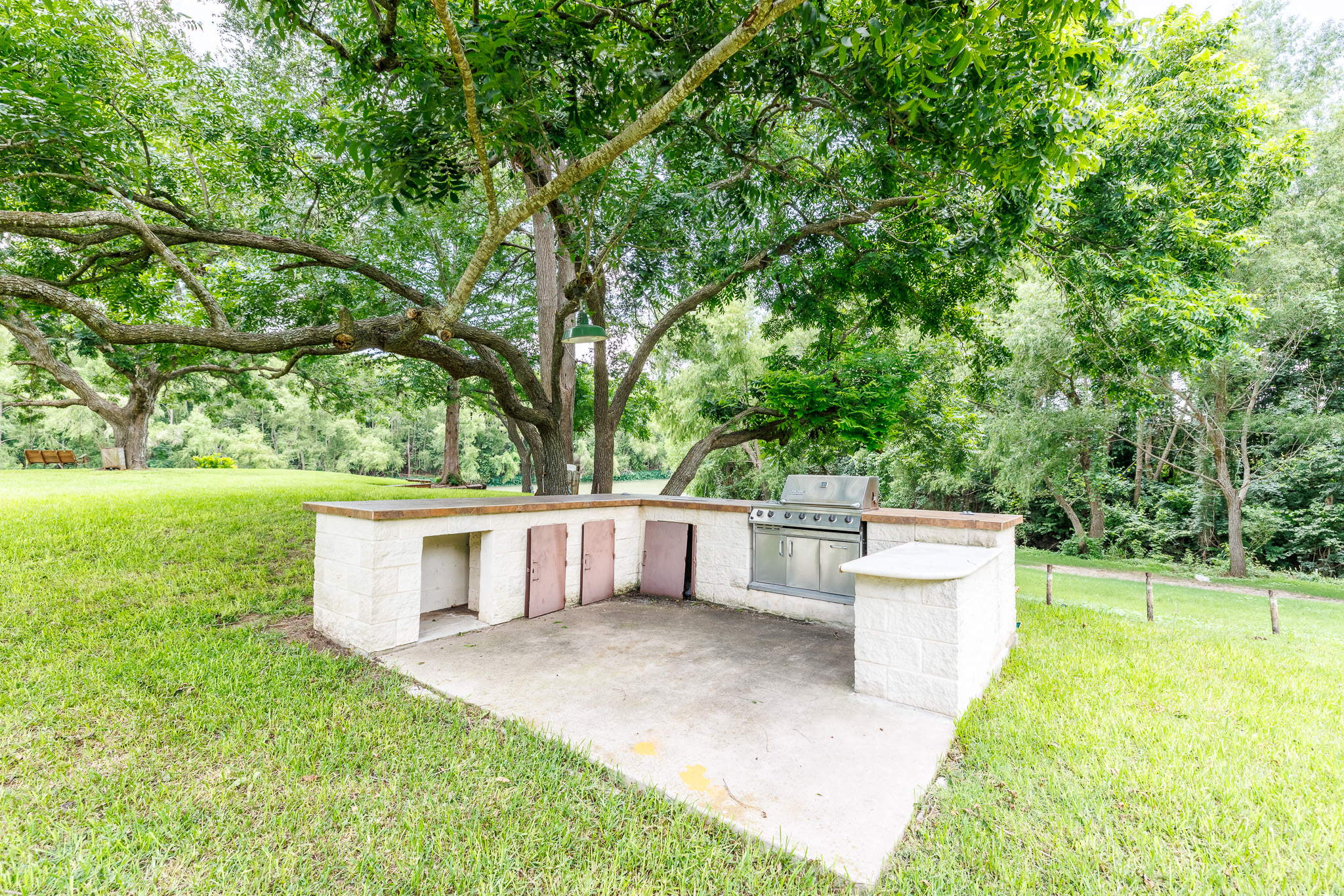 Tbd Goodwin Road Gonzales, TX 78629 - Photo 4 of 33 A built-in outdoor grill with ample counter space creates an ideal setting for al fresco dining amidst lush greenery.