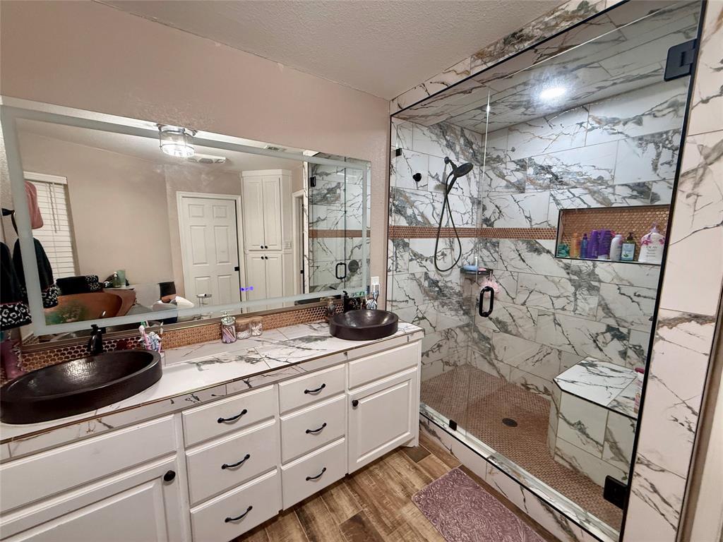 2007 Deep Water Road May, TX 76857 - Photo 12 of 40 a bathroom with a double vanity sink a mirror and shower