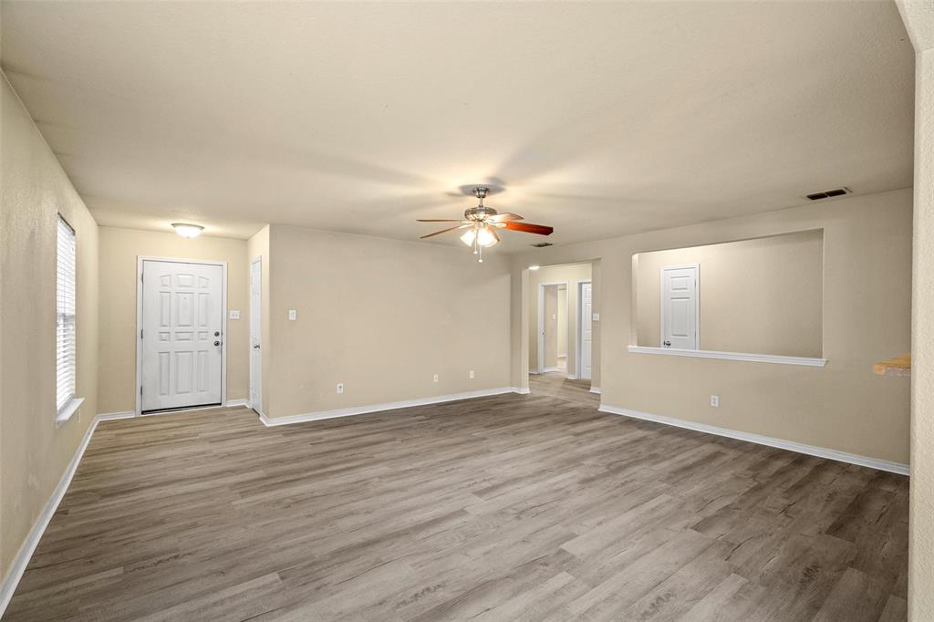 4024 Mantis Street Fort Worth, TX 76106 - Photo 9 of 27 a view of an empty room with wooden floor and a window