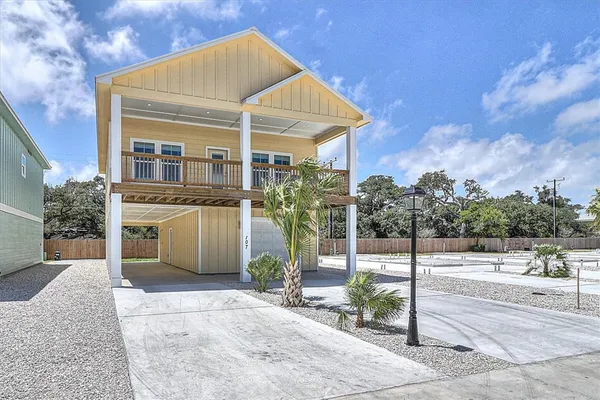 a front view of a house with a yard and potted plants