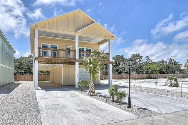 a front view of a house with a yard and potted plants