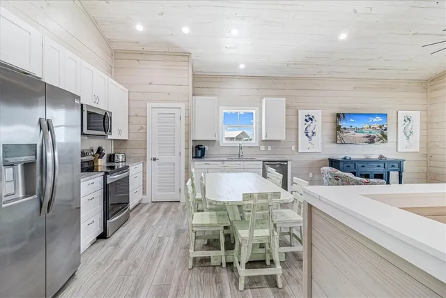 a kitchen with kitchen island a large counter top space appliances and cabinets
