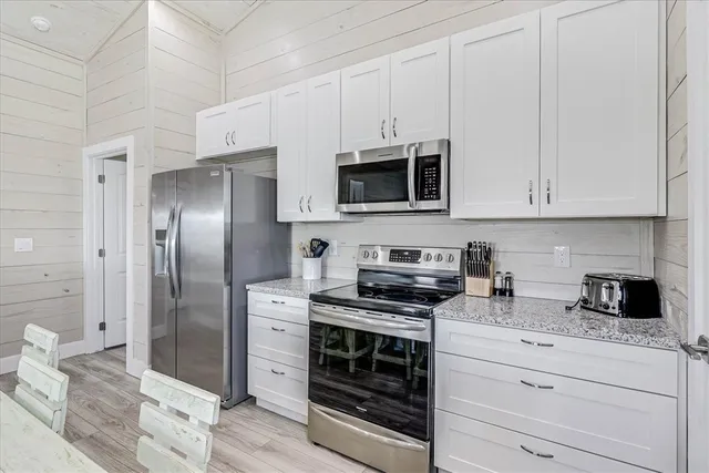 a kitchen with stainless steel appliances granite countertop a stove microwave and refrigerator