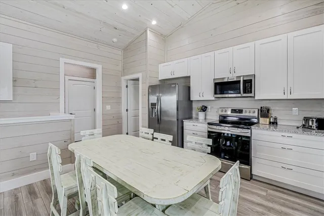 a kitchen with a stove a refrigerator and a dining table