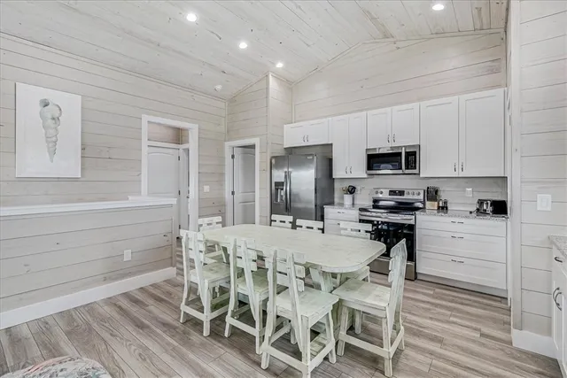 a kitchen with a table chairs stainless steel appliances and cabinets