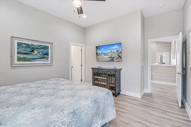 a spacious bedroom with a bed and a flat screen tv