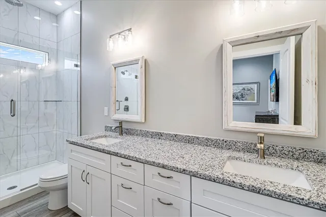 a bathroom with a granite countertop sink toilet and shower