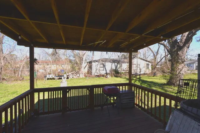 a view of a street with wooden floor next to a yard