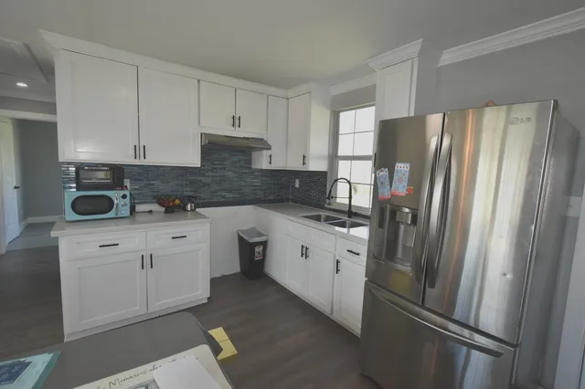 a kitchen with stainless steel appliances a refrigerator sink and cabinets