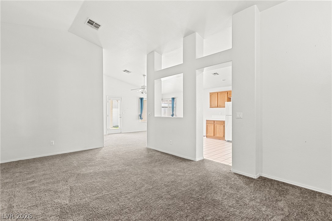 1815 Stablegate Avenue Henderson, NV 89012 - Photo 25 of 28 Well-lit living space with an open floor plan leading to the kitchen and an outdoor view.