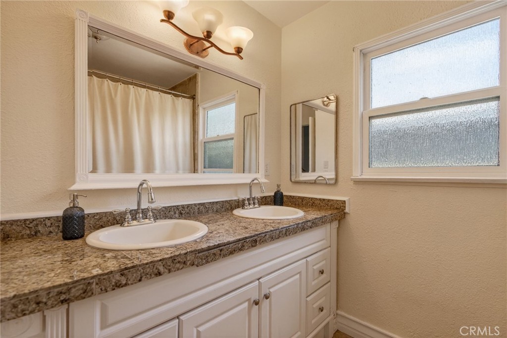 4194 Euclid Court Riverside, CA 92504 - Photo 17 of 29 Hallway bathroom with dual sinks and a spa tub with shower.