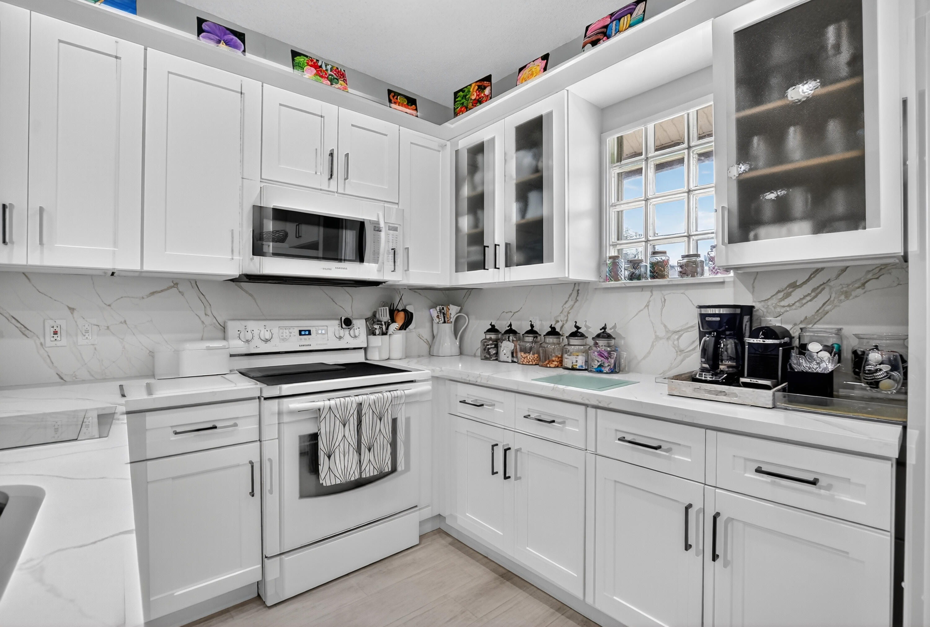 20220 Boca W Drive, Unit 202 Boca Raton, FL 33434 - Photo 13 of 129 a kitchen with stainless steel appliances granite countertop white cabinets a sink and dishwasher