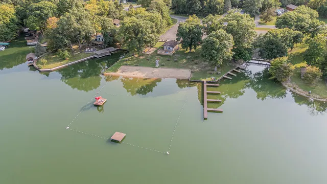 an aerial view of residential houses with outdoor space and lake view